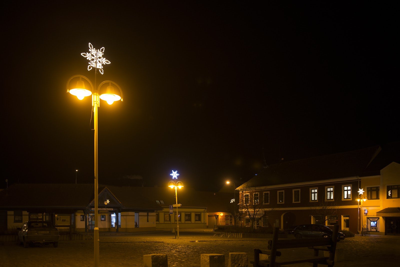 Světelný motiv hvězdy na vrcholu lampy veřejného osvětlení na náměstí.